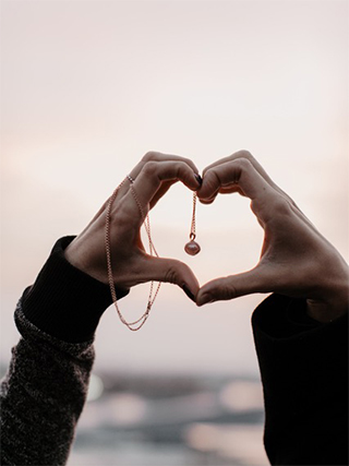 Erinnerungsstücke Hände mit Erinnerungsdiamantanhänger aus Asche